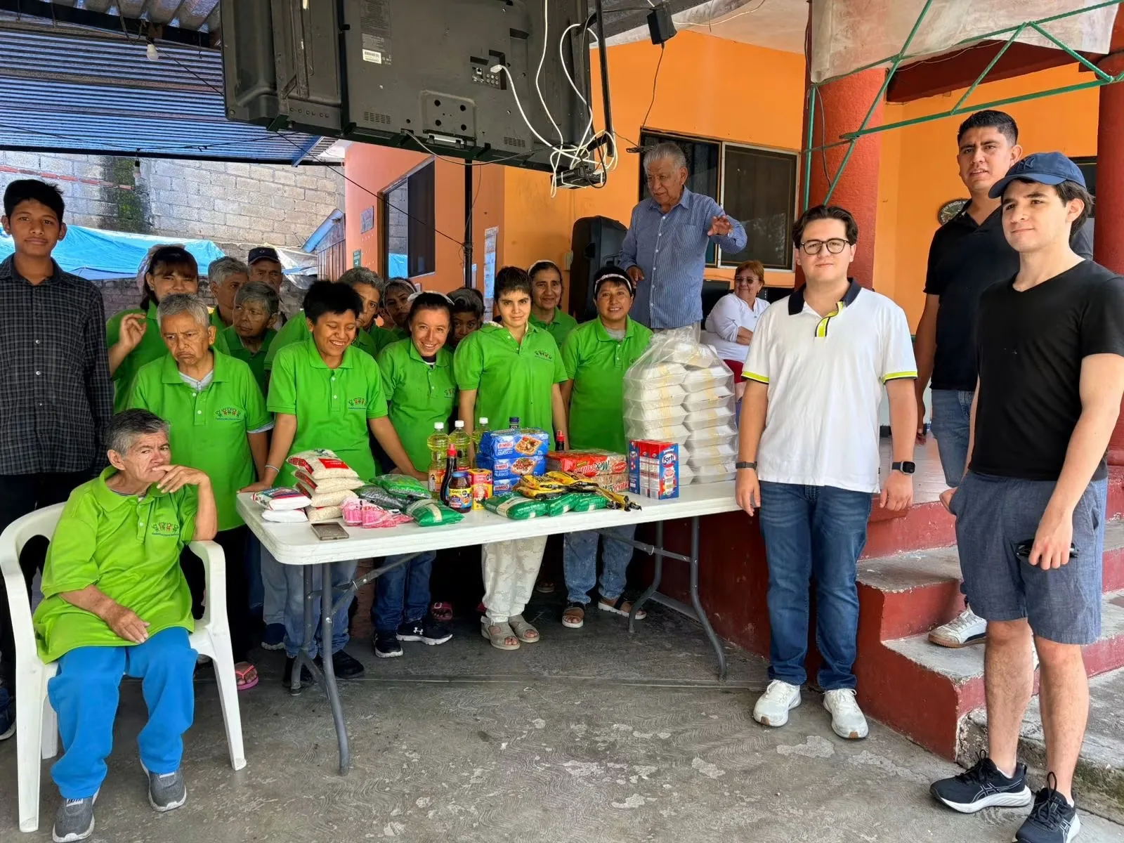 Comunidad de Amor y Gozo reunida con personas voluntarias y donativos